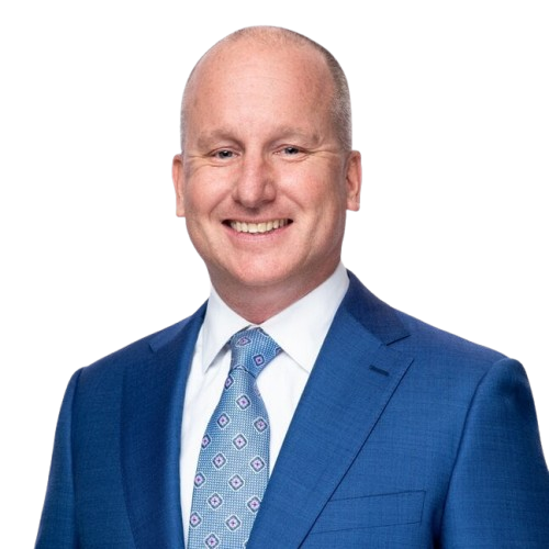 Headshot of a smiling bald white man in a blue suit and patterned tie.